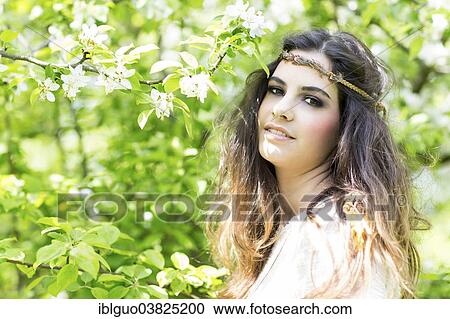 "Young woman wearing a headband, surrounded by blossoms" View Large Photo Image Stock Image - "Young woman wearing a headband, surrounded by blossoms". Fotosearch