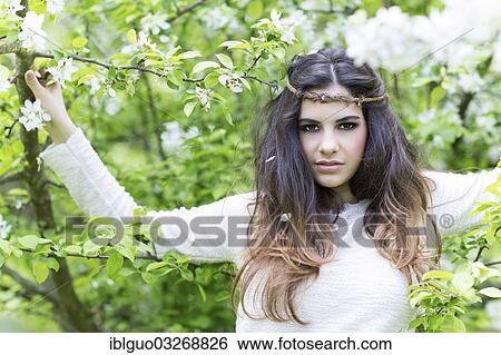 "Young woman wearing a headband, surrounded by blossoms" View Large Photo Image Stock Photograph - "Young woman wearing a headband, surrounded by blossoms". Fotosearch