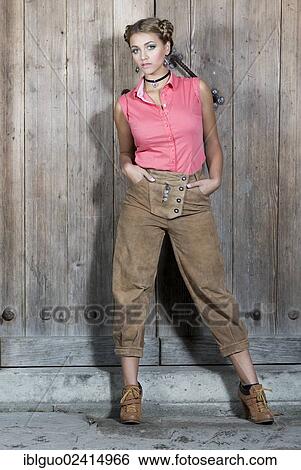 Young woman wearing a pink sleeveless top and traditional leather pants, dirndl look View Large Photo Image Stock Photograph - Young woman wearing a pink sleeveless top and traditional leather pants, dirndl look. Fotosearch