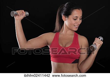 Young woman wearing a red sports bra while doing fitness training with chrome dumbbells View Large Photo Image Stock Image - Young woman wearing a red sports bra while doing fitness training with chrome dumbbells. Fotosearch