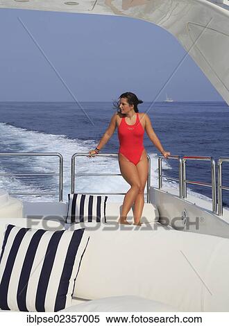 "Young woman wearing a red swimsuit standing on the back deck of a moving motor yacht, French Riviera, Cote d'Azur, Mediterranean Sea, Europe" View Large Photo Image Stock Photography - "Young woman wearing a red swimsuit standing on the back deck of a moving motor yacht, French Riviera, Cote d'Azur, Mediterranean Sea, Europe". Fotosearch