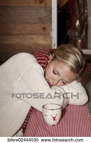 Young woman wearing a scarf sitting and sleeping at the table of a hiking hut View Large Photo Image Stock Photography - Young woman wearing a scarf sitting and sleeping at the table of a hiking hut. Fotosearch