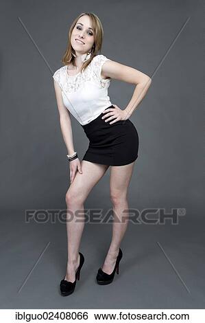 "Young woman wearing a white top, a short black skirt and high heels" View Large Photo Image Stock Photograph - "Young woman wearing a white top, a short black skirt and high heels". Fotosearch