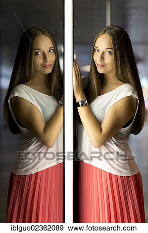 "Young woman wearing a white top and a red skirt, mirror image" View Large Photo Image Stock Photo - "Young woman wearing a white top and a red skirt, mirror image". Fotosearch