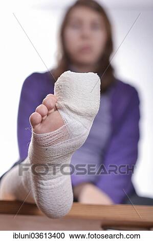 Stock Image - "Young woman with a bandaged toe, Germany, Europe". Fotosearch