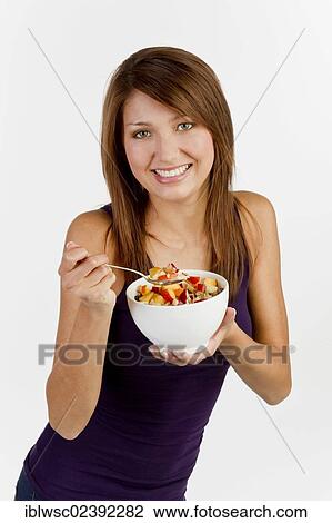 Young woman with a bowl of cereal View Large Photo Image Stock Image - Young woman with a bowl of cereal. Fotosearch