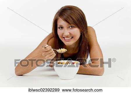 Young woman with a bowl of cereal View Large Photo Image Stock Photo - Young woman with a bowl of cereal. Fotosearch