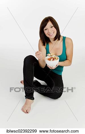 Young woman with a bowl of cereal View Large Photo Image Stock Photo - Young woman with a bowl of cereal. Fotosearch