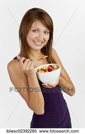 Stock Photography - Young woman with a bowl of cereal. Fotosearch