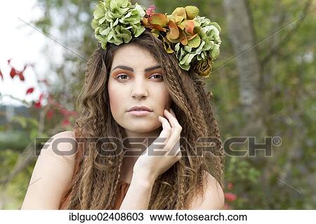 Stock Image - "Young woman with a flowal wreath in her hair, outdoors, portrait". Fotosearch