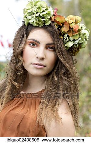 "Young woman with a flowal wreath in her hair, outdoors, portrait" View Large Photo Image Stock Photograph - "Young woman with a flowal wreath in her hair, outdoors, portrait". Fotosearch