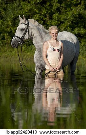 Young woman with a Hanoverian horse in a lake View Large Photo Image Stock Image - Young woman with a Hanoverian horse in a lake. Fotosearch