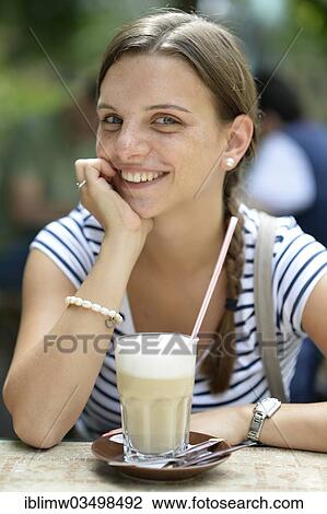 Stock Image - "Young woman with a latte macchiato, Heidelberg, Baden-Wurttemberg, Germany, Europe". Fotosearch