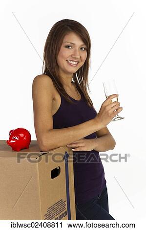 "Young woman with a moving box and a glass of champagne in her hand, smiling" View Large Photo Image Stock Image - "Young woman with a moving box and a glass of champagne in her hand, smiling". Fotosearch