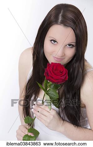 Stock Image - Young woman with a red rose. Fotosearch