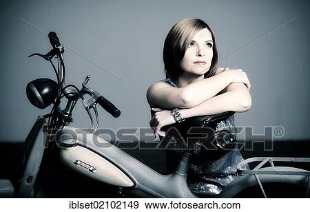 Young woman with a vintage Motom motorcycle View Large Photo Image Stock Photo - Young woman with a vintage Motom motorcycle. Fotosearch