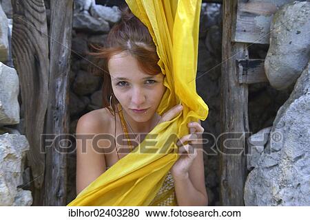 Young woman with a yellow silk scarf in front of a stone hut View Large Photo Image Stock Image - Young woman with a yellow silk scarf in front of a stone hut. Fotosearch