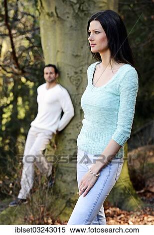Stock Photography - "Young woman with a young man leaning against a tree at back, Austria, Europe". Fotosearch