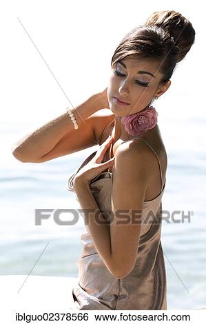 "Young woman with an updo hairstyle and a silvery evening dress, seated" View Large Photo Image Stock Photograph - "Young woman with an updo hairstyle and a silvery evening dress, seated". Fotosearch
