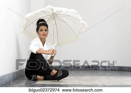 "Young woman with an updo hairstyle, wearing a white shirt, black leggings and high heels, holding a white umbrella" View Large Photo Image Picture - "Young woman with an updo hairstyle, wearing a white shirt, black leggings and high heels, holding a white umbrella". Fotosearch