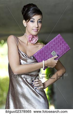 "Young woman with an updo hairstyle, silvery evening dress and a clutch bag" View Large Photo Image Stock Photography - "Young woman with an updo hairstyle, silvery evening dress and a clutch bag". Fotosearch