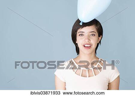 Stock Image - Young woman with blue balloon. Fotosearch