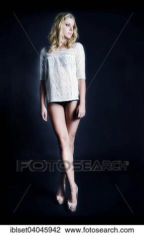 Stock Image - Young woman with braided hair wearing a lace top. Fotosearch