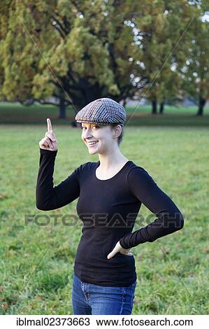 Young woman with cap and pointing index finger View Large Photo Image Stock Image - Young woman with cap and pointing index finger. Fotosearch