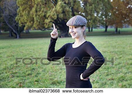 Young woman with cap and pointing index finger View Large Photo Image Stock Photo - Young woman with cap and pointing index finger. Fotosearch