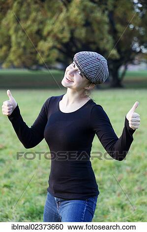 "Young woman with cap, two thumbs up" View Large Photo Image Stock Image - "Young woman with cap, two thumbs up". Fotosearch