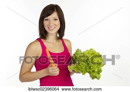 Picture - Young woman with carrot and lettuce. Fotosearch