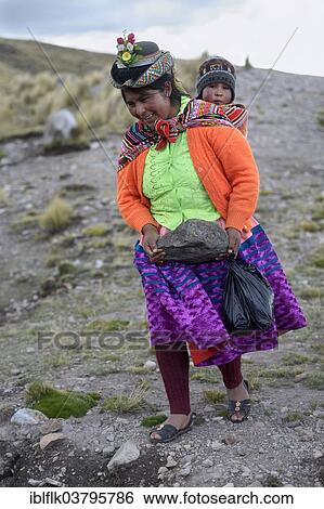 "Young woman with child in a sling carrying a heavy stone to secure the shores of an artificial lake for irrigation, Quispillacta, Ayacucho, Peru, South America" View Large Photo Image Stock Photograph - "Young woman with child in a sling carrying a heavy stone to secure the shores of an artificial lake for irrigation, Quispillacta, Ayacucho, Peru, South America". Fotosearch