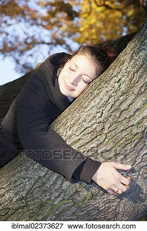 Young woman with closed eyes on a tree in autumn View Large Photo Image Stock Photo - Young woman with closed eyes on a tree in autumn. Fotosearch