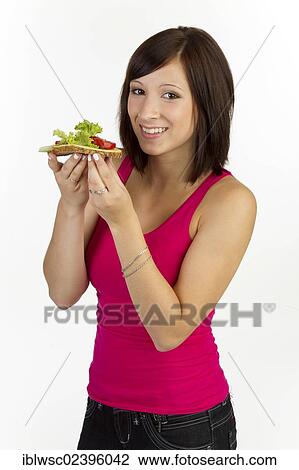 Young woman with grain bread topped with cheese and tomato View Large Photo Image Stock Image - Young woman with grain bread topped with cheese and tomato. Fotosearch