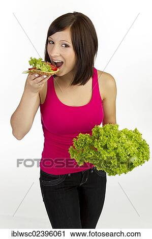 Young woman with grain bread topped with cheese and tomato and lettuce in the other hand View Large Photo Image Stock Image - Young woman with grain bread topped with cheese and tomato and lettuce in the other hand. Fotosearch