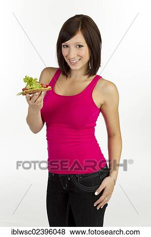 Young woman with grain bread topped with cheese and tomato View Large Photo Image Stock Photo - Young woman with grain bread topped with cheese and tomato. Fotosearch