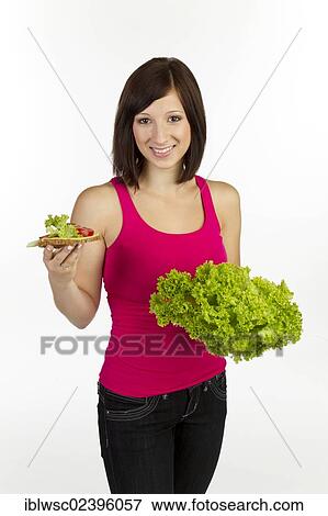 Young woman with grain bread topped with cheese and tomato and lettuce in the other hand View Large Photo Image Stock Photo - Young woman with grain bread topped with cheese and tomato and lettuce in the other hand. Fotosearch