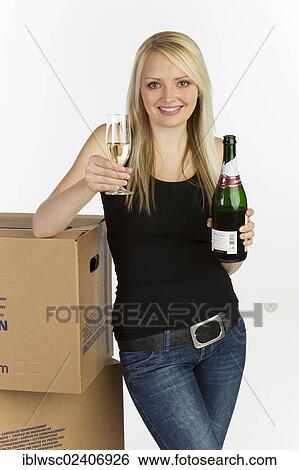 "Young woman with moving boxes, bottle and glass of champagne" View Large Photo Image Stock Photograph - "Young woman with moving boxes, bottle and glass of champagne". Fotosearch