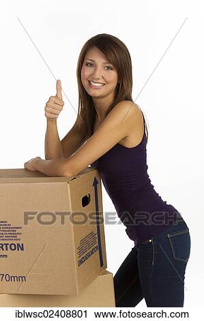 "Young woman with moving boxes, making a thumbs-up gesture" View Large Photo Image Stock Image - "Young woman with moving boxes, making a thumbs-up gesture". Fotosearch