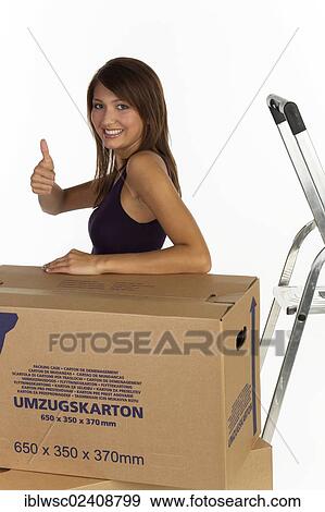"Young woman with moving boxes, making a thumbs-up gesture" View Large Photo Image Stock Photo - "Young woman with moving boxes, making a thumbs-up gesture". Fotosearch