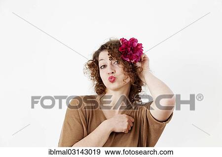 Young woman with red lips and a flower in her hair View Large Photo Image Stock Photo - Young woman with red lips and a flower in her hair. Fotosearch