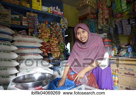 Stock Photo - "Young woman with veil, assistant in a small grocery store, Lam Rukam, Subdistrict Rozma, Aceh, Indonesia, Asia". Fotosearch