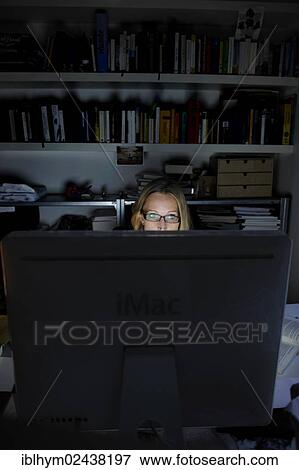 Young woman working on a computer at night View Large Photo Image Stock Photo - Young woman working on a computer at night. Fotosearch