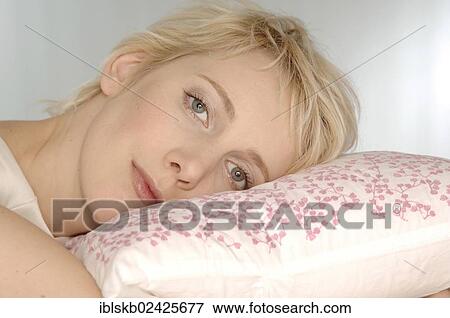 Stock Photo - Young woman's head lying on a pillow. Fotosearch