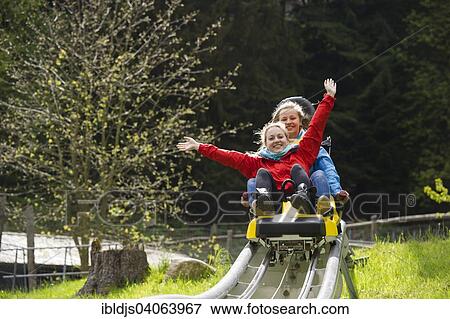 Stock Photo - "Young women on a summer toboggan run, Steinwasenpark in Oberried, Black Forest, Baden-Wurttemberg, Germany, Europe". Fotosearch