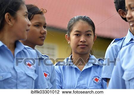 Stock Image - "Young women wearing uniforms of the Red Cross during a training course for young people to become first aid workers by the Red Cross, Tropeng Village, Bathi District, Takeo Province, Cambodia, Asia". Fotosearch