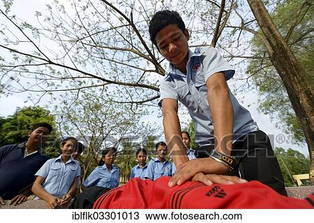 "Youth performing a resuscitation procedure, training of young people from the community to become first aid workers by the Red Cross, Tropeng Village, Bathi District, Takeo Province, Cambodia, Asia" View Large Photo Image Stock Image - "Youth performing a resuscitation procedure, training of young people from the community to become first aid workers by the Red Cross, Tropeng Village, Bathi District, Takeo Province, Cambodia, Asia". Fotosearch