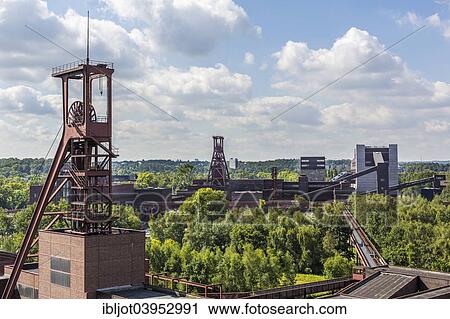 Stock Image - "Zeche Zollverein, former coal mine, UNESCO World Heritage Site, headframe, Shaft 1-2-8 and Shaft 12, Ruhrmuseum at the back, Essen, North Rhine-Westphalia, Germany, Europe". Fotosearch