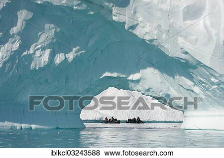 Stock Photo - "Zodiac inflatable boats seen through the arch of a large iceberg, Pleneau Bay, Antarctic Peninsula, Antarctica". Fotosearch