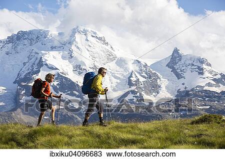 A man and a woman hiking, Schweifinen Plateau at the back the mountains Breithorn and Klein Matterhorn, Zermatt, Canton of Valais, Switzerland, Europe View Large Photo Image Stock Image - A man and a woman hiking, Schweifinen Plateau at the back the mountains Breithorn and Klein Matterhorn, Zermatt, Canton of Valais, Switzerland, Europe. Fotosearch